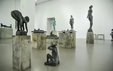 Muzei Suchasnoho Mystetstva in Kyiv - bright gallery hall displaying a collection of modern bronze sculptures on rough stone pedestals