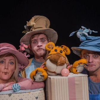 Kyiv Academic Puppet Theatre in Kyiv - three actors in colorful whimsical costumes and funny hats making expressive faces during a performance