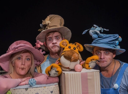 Kyiv Academic Puppet Theatre in Kyiv - three actors in colorful whimsical costumes and funny hats making expressive faces during a performance