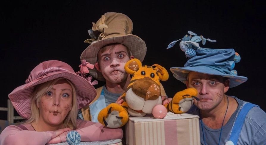 Kyiv Academic Puppet Theatre in Kyiv - three actors in colorful whimsical costumes and funny hats making expressive faces during a performance