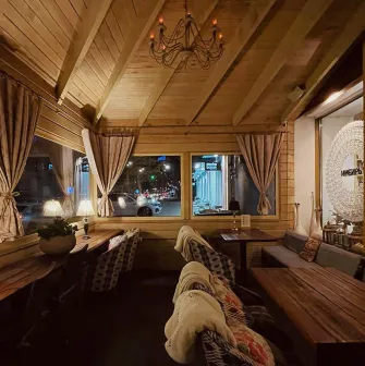 Restaurant Imbyr - cozy wooden balcony dining area with blankets and views of the street