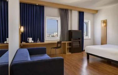 Ibis Kyiv City Center in Kyiv - room interior with blue curtains, sofa and desk