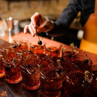 Bartender preparing red cherry cocktails at Alchemist Bar