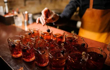 Bartender preparing red cherry cocktails at Alchemist Bar