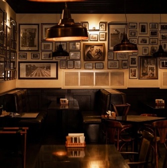 Goodman Steak House - dining tables set with plates, glassware, and white linens for guests