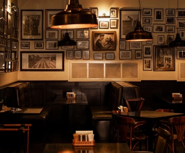 Goodman Steak House - dining tables set with plates, glassware, and white linens for guests