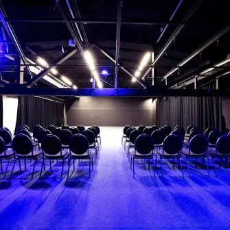 The large Pochayna Event Hall in Kyiv with a screen for projections and seating for the audience