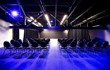 The large Pochayna Event Hall in Kyiv with a screen for projections and seating for the audience
