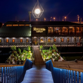 Restaurant Khutorets na Dnipri - exterior view of the restaurant at night over the water