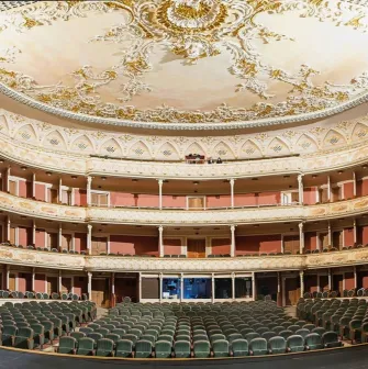 Teatr Franka in Kyiv - majestic panoramic view of the empty theater hall showcasing the painted ceiling, gold decorations, and rows of velvet seats