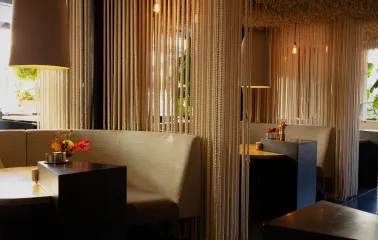 Restaurant Odesa - dining booths separated by ceiling-to-floor rope curtains