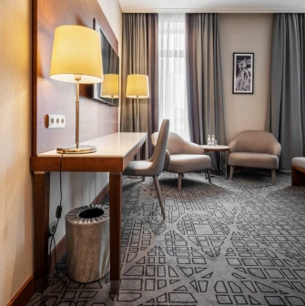 City Hotel in Kyiv - room interior featuring work desk, mirror and two grey armchairs