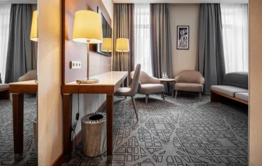 City Hotel in Kyiv - room interior featuring work desk, mirror and two grey armchairs