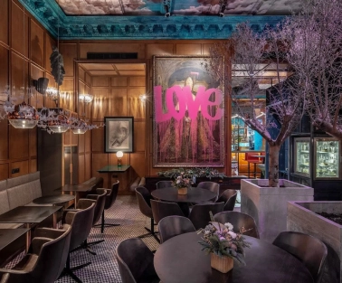 Restaurant Italiiska Redaktsiia - stylish dining room with a large LOVE painting and decorative trees