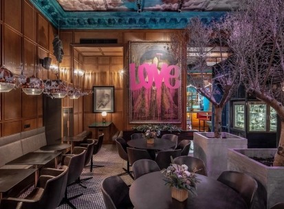 Restaurant Italiiska Redaktsiia - stylish dining room with a large LOVE painting and decorative trees