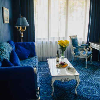 A luxurious blue-toned suite with a sofa at the Royal Olympic Hotel in Kyiv