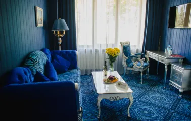 A luxurious blue-toned suite with a sofa at the Royal Olympic Hotel in Kyiv