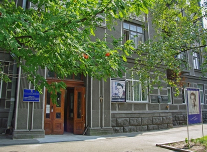 Muzei Tychyny in Kyiv - exterior entrance to the museum apartment located in a historic grey building with a large portrait of the poet displayed outside