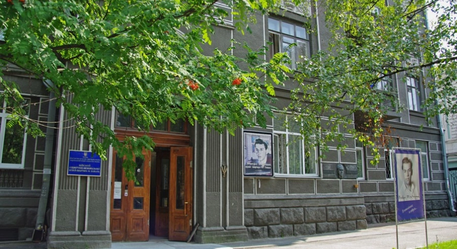 Muzei Tychyny in Kyiv - exterior entrance to the museum apartment located in a historic grey building with a large portrait of the poet displayed outside