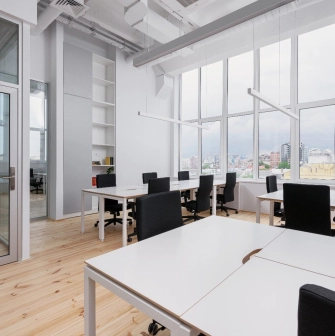 Workspace at Kooperativ with a large window and black office chairs