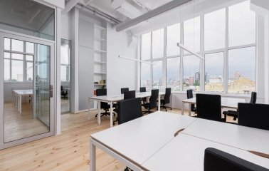 Workspace at Kooperativ with a large window and black office chairs