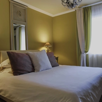 Vozdvyzhenskyi in Kyiv - bedroom suite featuring a large bed, green curtains, and vintage lamps