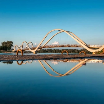 Azov Wave Bridge in Kyiv - white wave-shaped bridge reflecting in the water surface