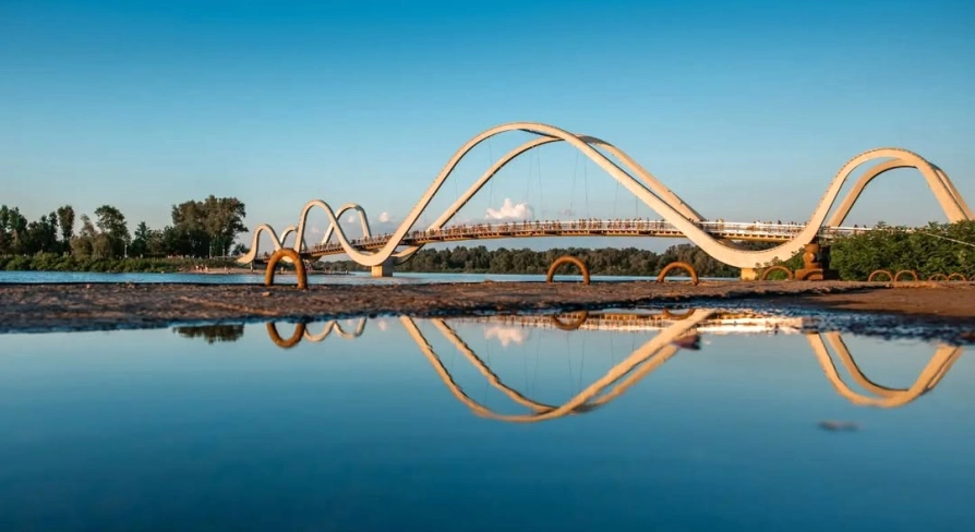 Azov Wave Bridge in Kyiv - white wave-shaped bridge reflecting in the water surface