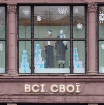 The winter window display of the Vsi. Svoi" store in Kyiv with mannequins, snowflakes and gift boxes