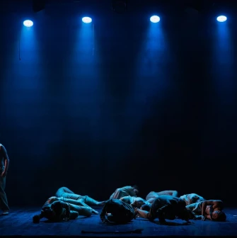 Mala Opera in Kyiv - a tense stage scene showing a lone actor and a group of performers lying on the floor