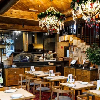 Restaurant Mama Manana - interior with dining tables and a pizza oven