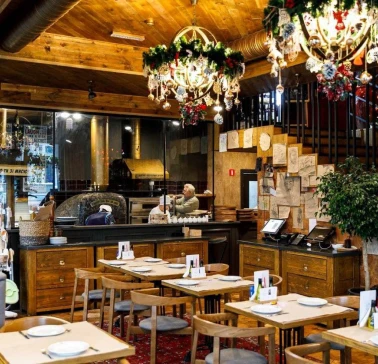 Restaurant Mama Manana - interior with dining tables and a pizza oven