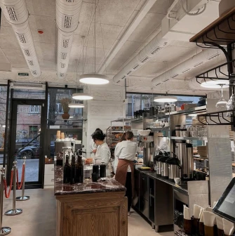 Spelta - baker working in the open kitchen preparing dough near the oven