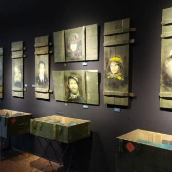 Museum exhibition with portraits of soldiers on ammunition boxes