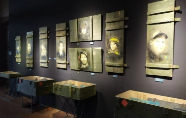 Museum exhibition with portraits of soldiers on ammunition boxes