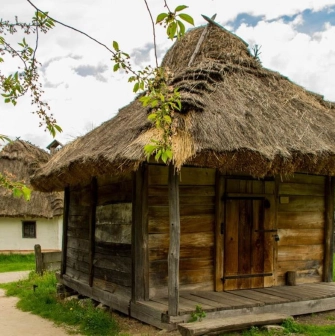 A traditional peasant hut with a wooden roof in the Pirogues Museum in Kyiv
