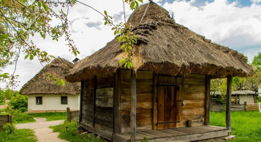 A traditional peasant hut with a wooden roof in the Pirogues Museum in Kyiv