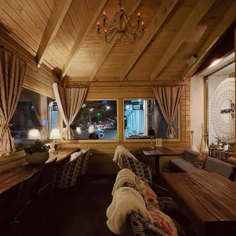 Restaurant Imbyr - cozy wooden balcony dining area with blankets and views of the street