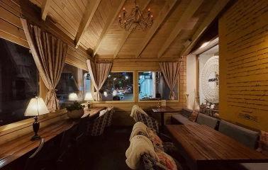 Restaurant Imbyr - cozy wooden balcony dining area with blankets and views of the street