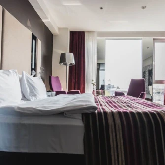 Spacious room at 11 Mirrors Design Hotel in Kyiv with a panoramic window, modern interior and city views