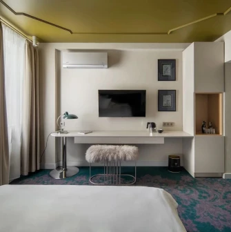 Vozdvyzhenskyi in Kyiv - room with white desk, green carpet and gold ceiling