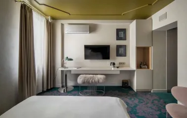 Vozdvyzhenskyi in Kyiv - room with white desk, green carpet and gold ceiling