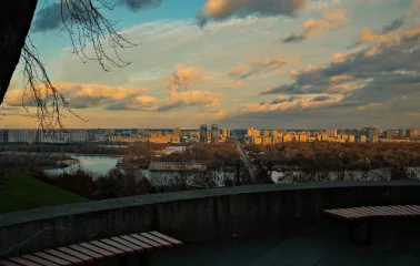 Park of Eternal Glory in Kyiv - sunset view of the Dnipro river and left bank from a stone terrace with benches