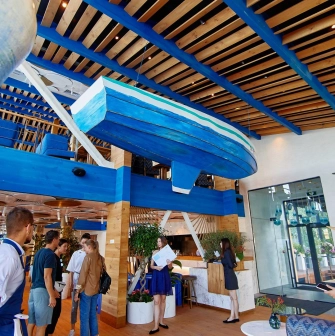 Prychal – bright nautical interior with hanging blue boat and wooden ceiling beams