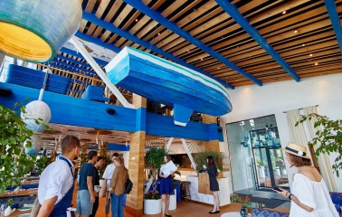 Prychal – bright nautical interior with hanging blue boat and wooden ceiling beams