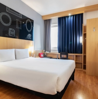 Ibis Railway Station in Kyiv - bedroom with white bed and black chalkboard wall