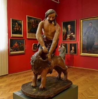 National Art Museum of Ukraine in Kyiv - a sculpture of Samson tearing open the mouth of a lion stands in a hall with portraits
