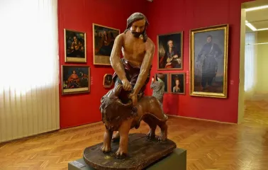 National Art Museum of Ukraine in Kyiv - a sculpture of Samson tearing open the mouth of a lion stands in a hall with portraits