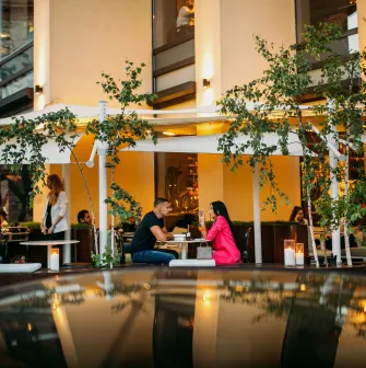 BEEF meat & wine - cozy outdoor terrace with tables and chairs near the railing