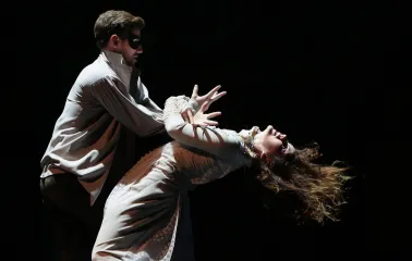 Teatr Lesi Ukrainky in Kyiv - dramatic scene featuring an actor in a mask holding a woman in a white dress